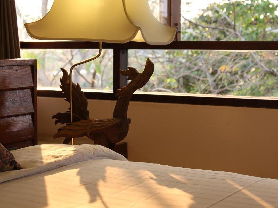 Bedside lamp and balcony view in a Baan Tye Wang Hotel room