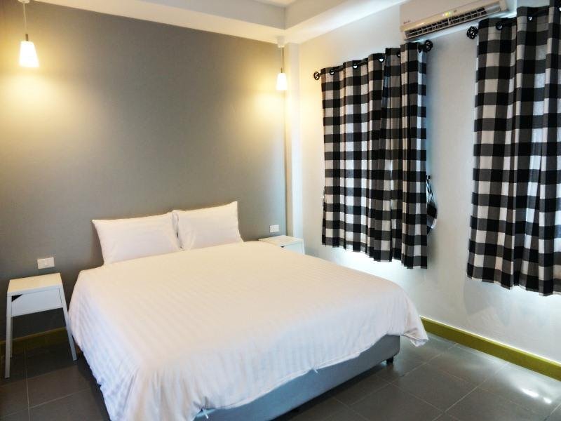 Double bed and checked curtains in a Kata Bai D room