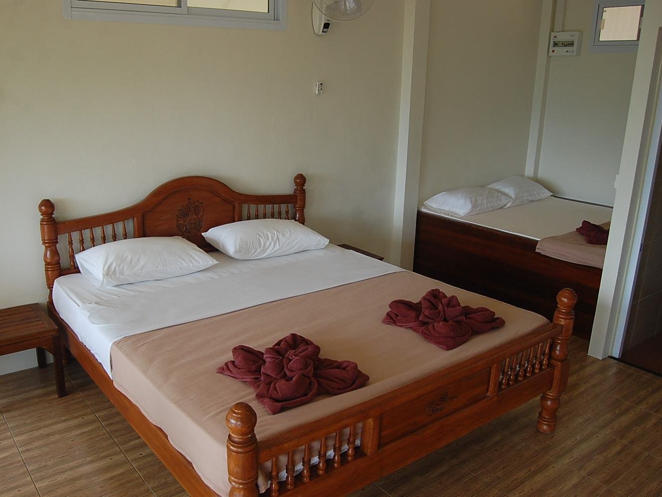 Wooden double bed and a second bed inside a room at Khao Sok Hill Top Resort