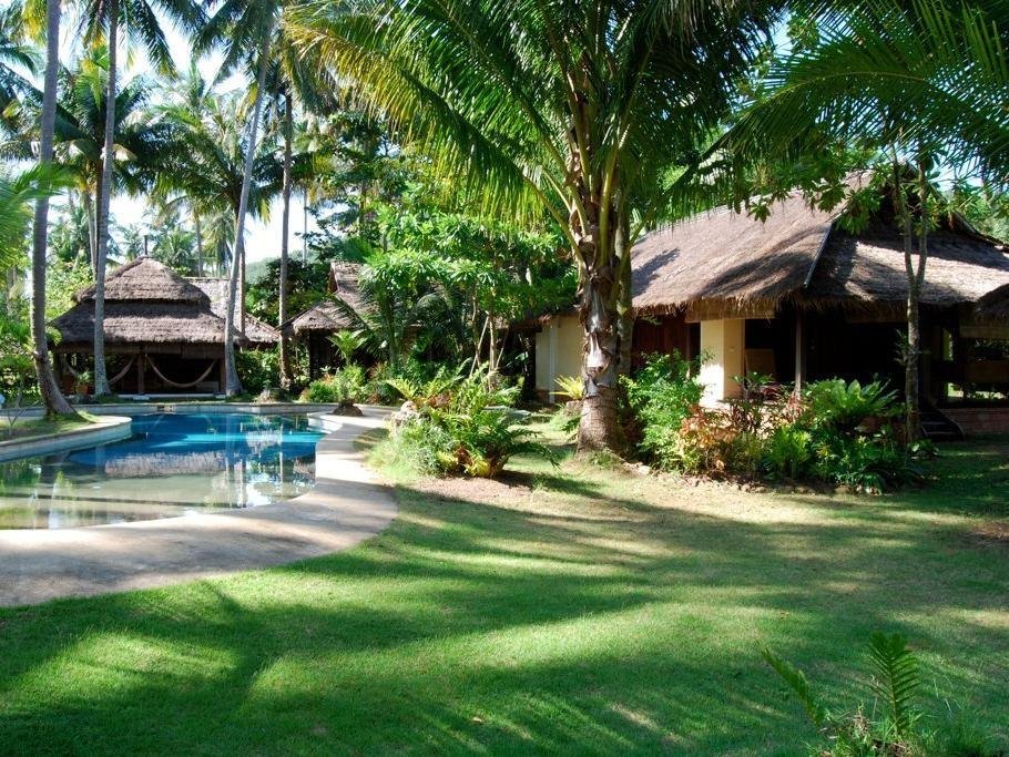 Swimming pool and pavilion buildings among palms at Koyao Bay Pavilions