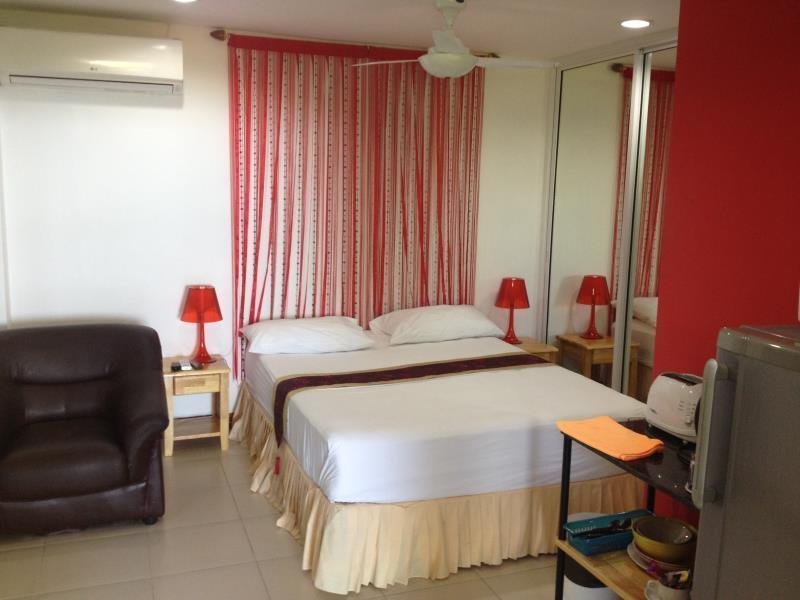 Double bed, seating and refrigerator inside a Mountain Seaview apartment