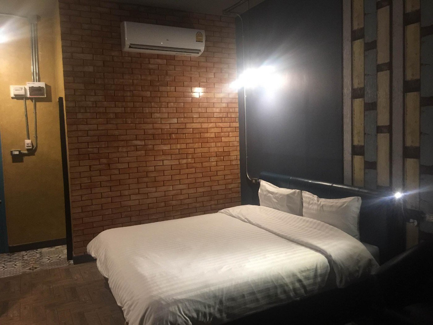 Guest bed and brick-wall interior at One Beat Vintage&Bistro