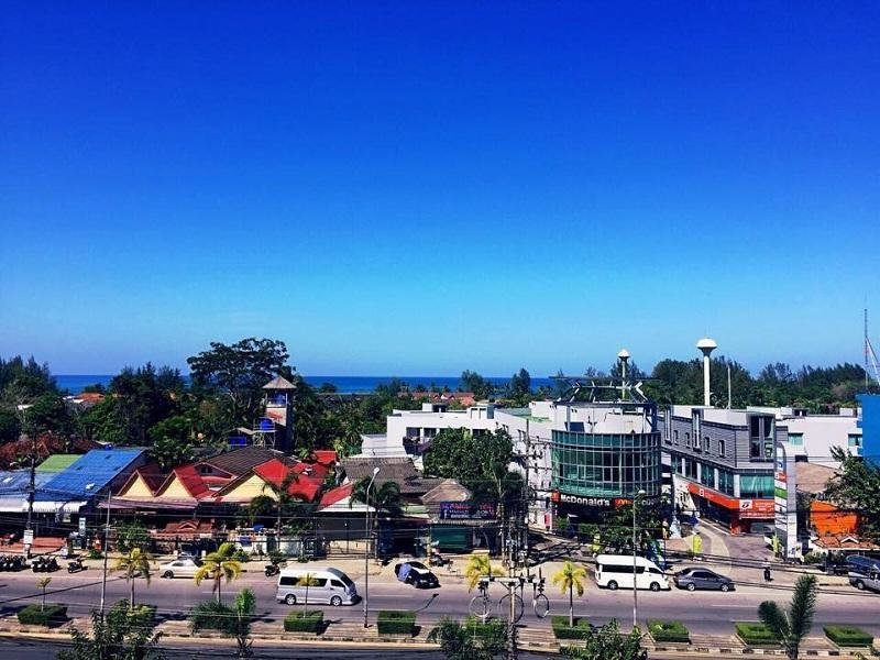 View across the main road and rooftops towards the sea at Rakkawan Residence