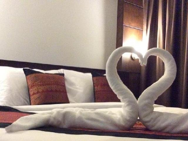 Towel swans arranged on a double bed at Rakkawan Residence