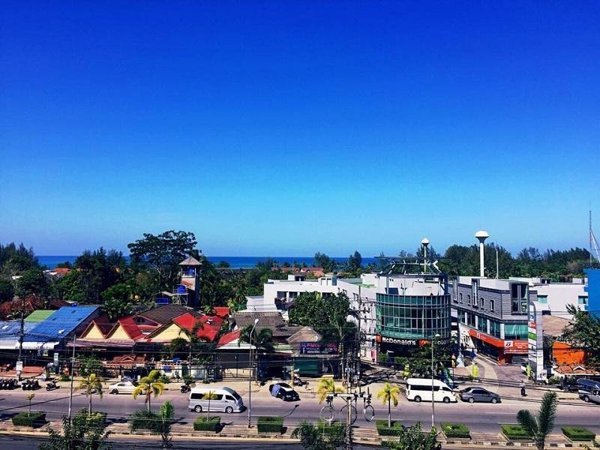 View across the main road and rooftops towards the sea at Rakkawan Residence