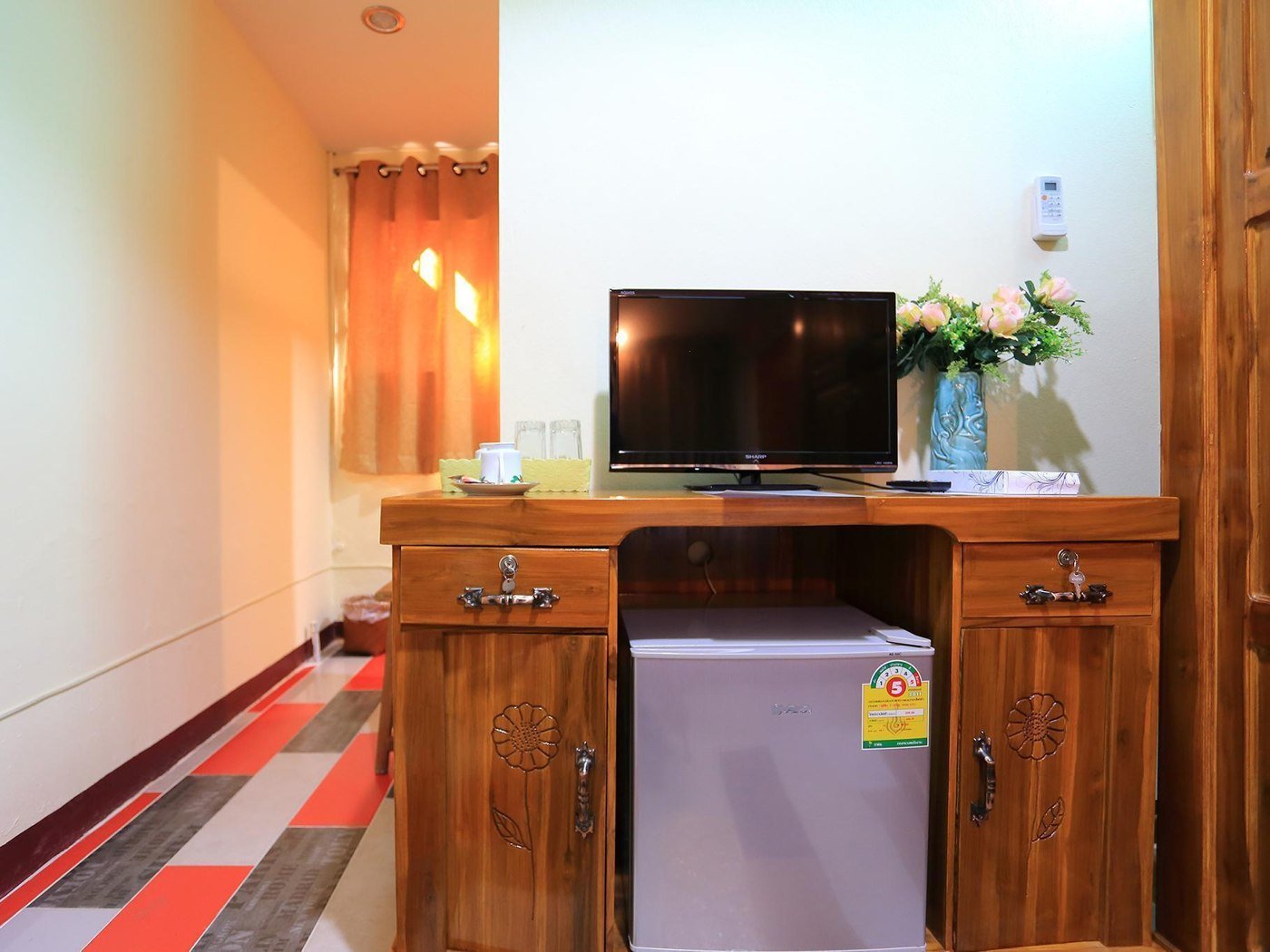 Guest-room television, refrigerator and storage at Saithong House