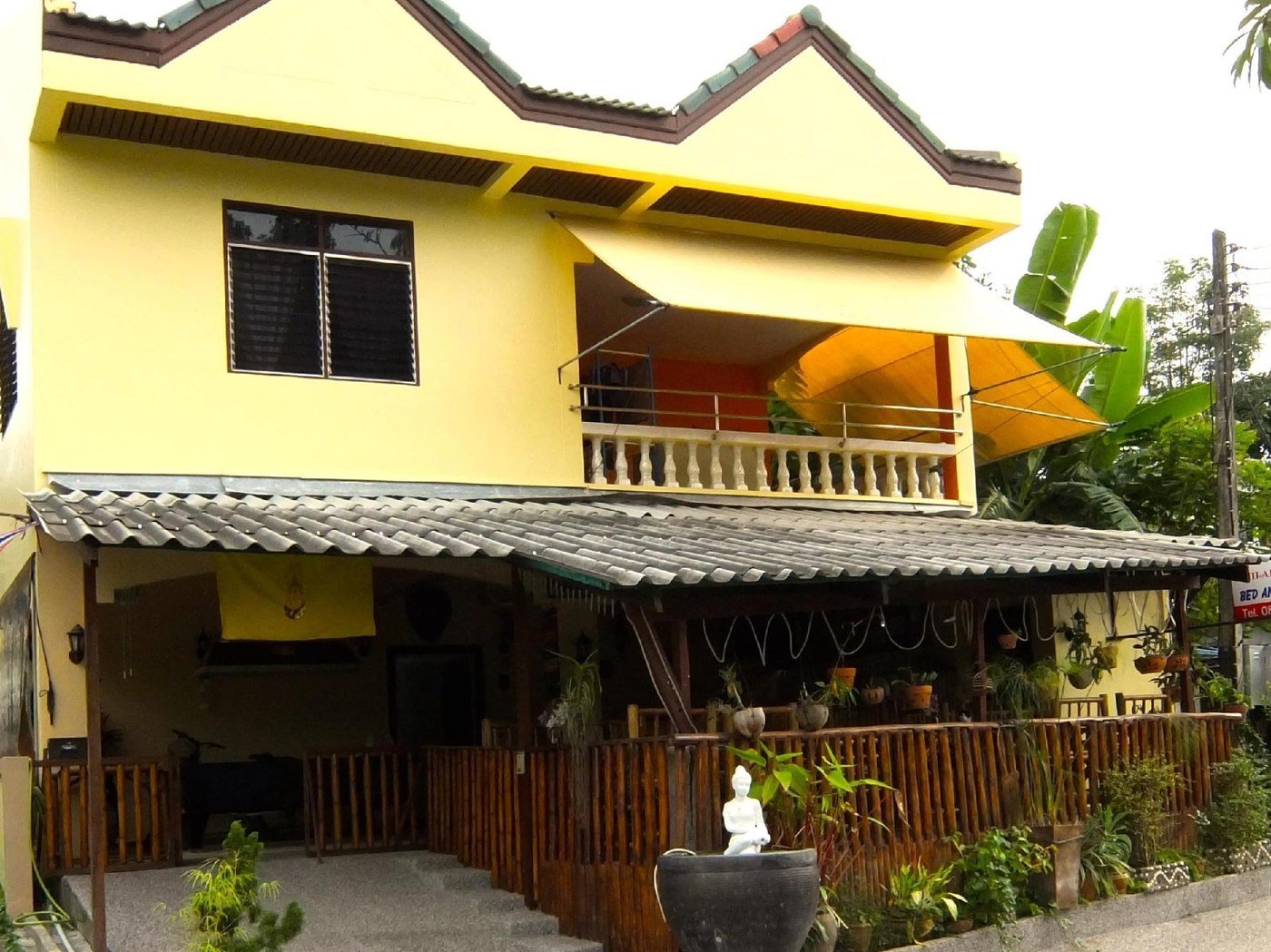 Yellow Similan Hotel building with a shaded ground-floor terrace