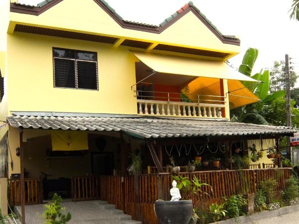 Yellow Similan Hotel building with a shaded ground-floor terrace