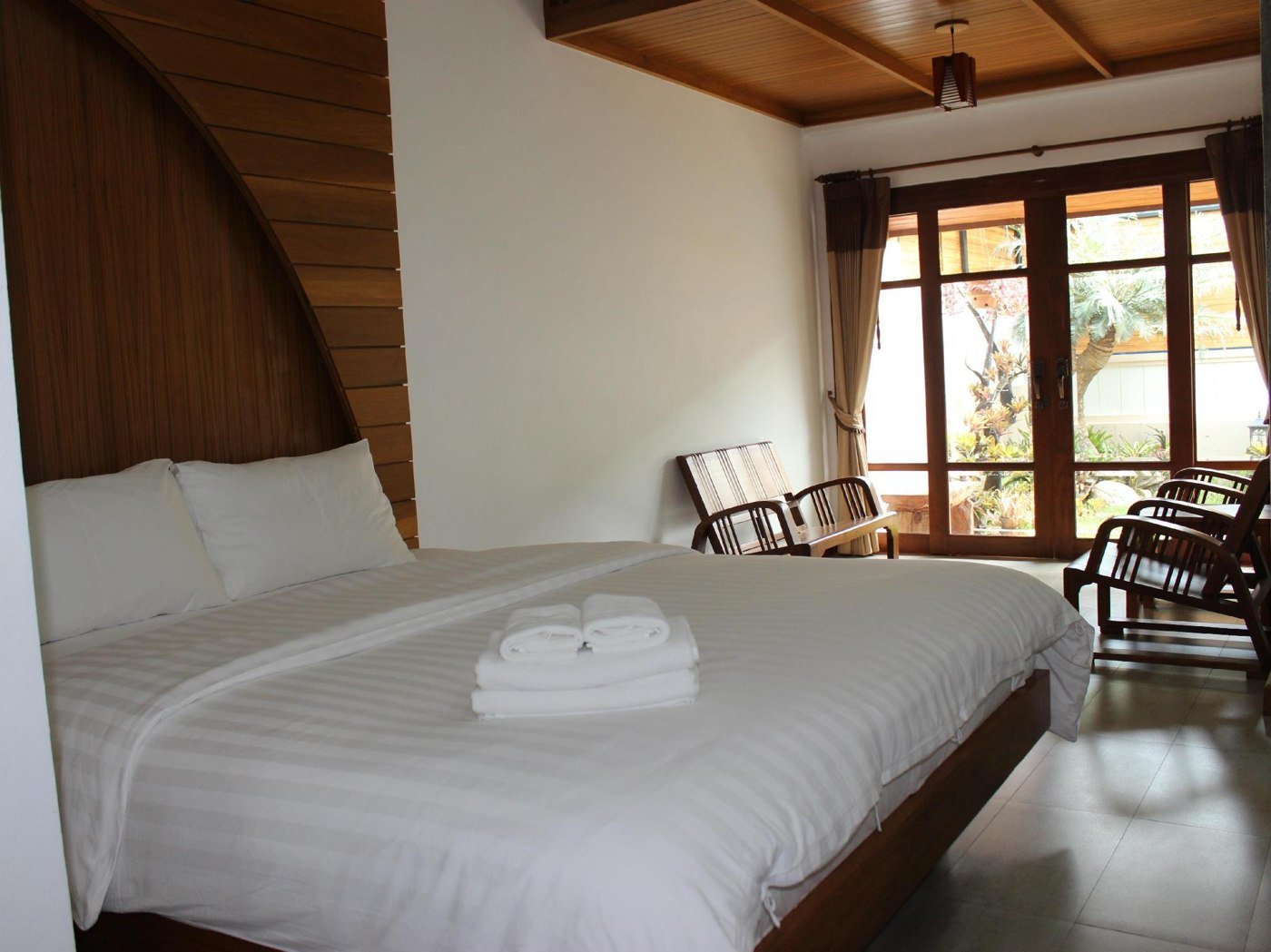 Double bedroom with wooden ceiling and glass doors at Tree Home Plus