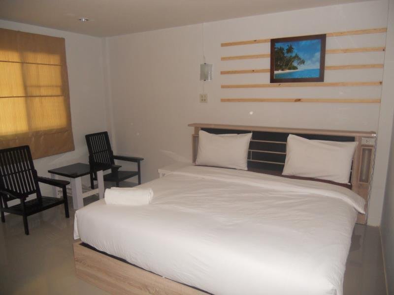 Double bed and two chairs inside a Werot Resort room