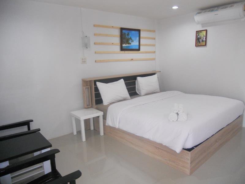 Double bed, small table and wall-mounted air conditioner in a Werot Resort room