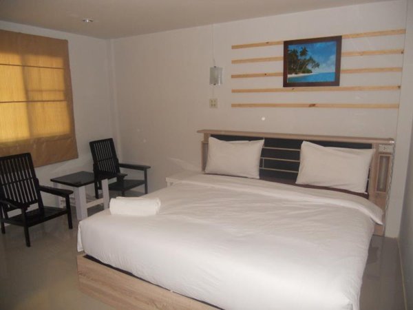 Double bed and two chairs inside a Werot Resort room